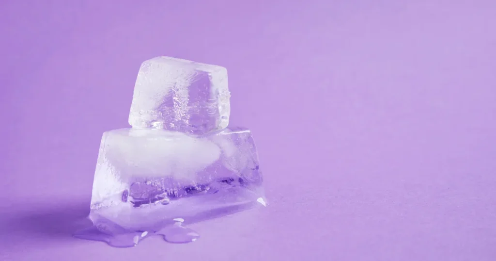 紫の背景に置かれた2つの氷。少しずつ溶けはじめている様子。